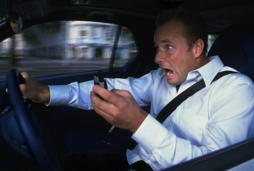 Uomo con telefono al volante Uomo con telefono al volante